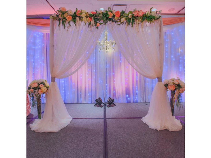 20' to 25' metal arch with chandelier, flowers, backdrop and lights