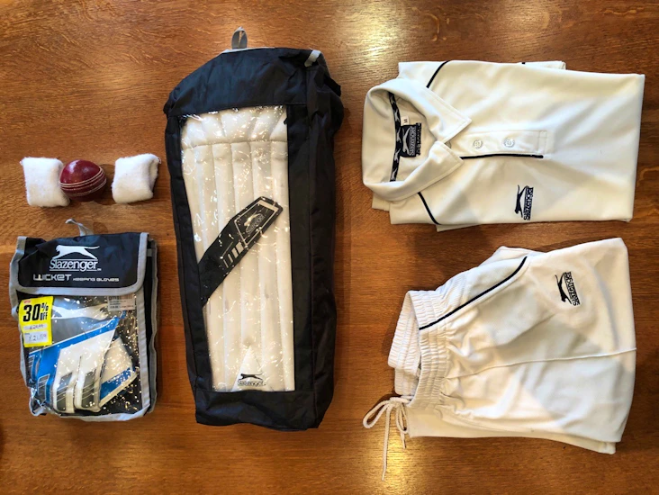 Men’s wicket keeper cricket attire with pads, gloves & ball. (but no helmet)