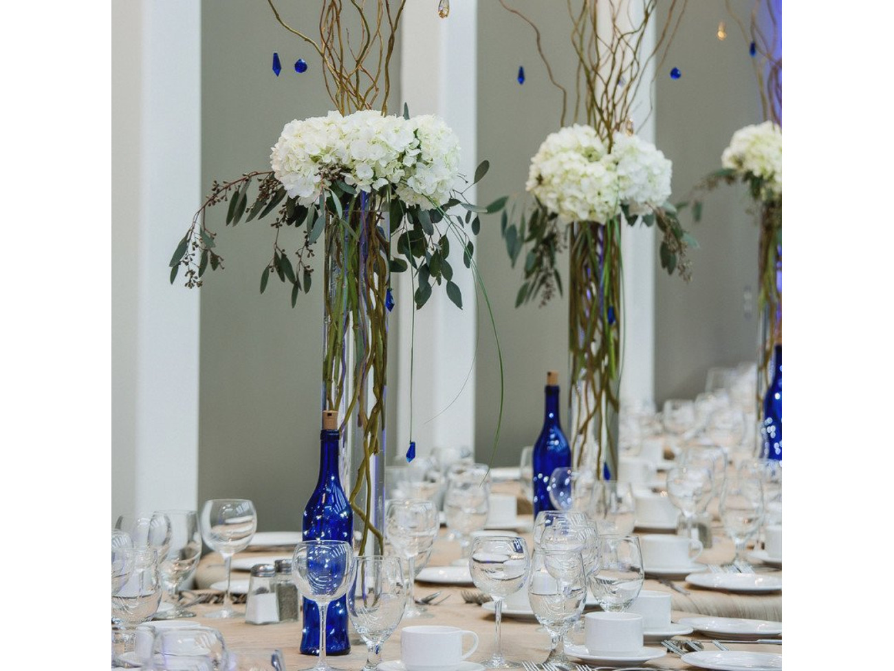 Tall vase with fresh flowers and branches