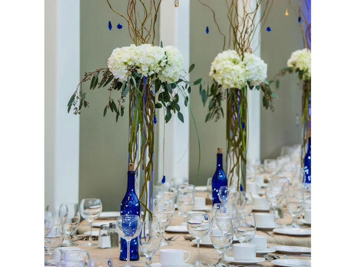 Tall vase with fresh flowers and branches