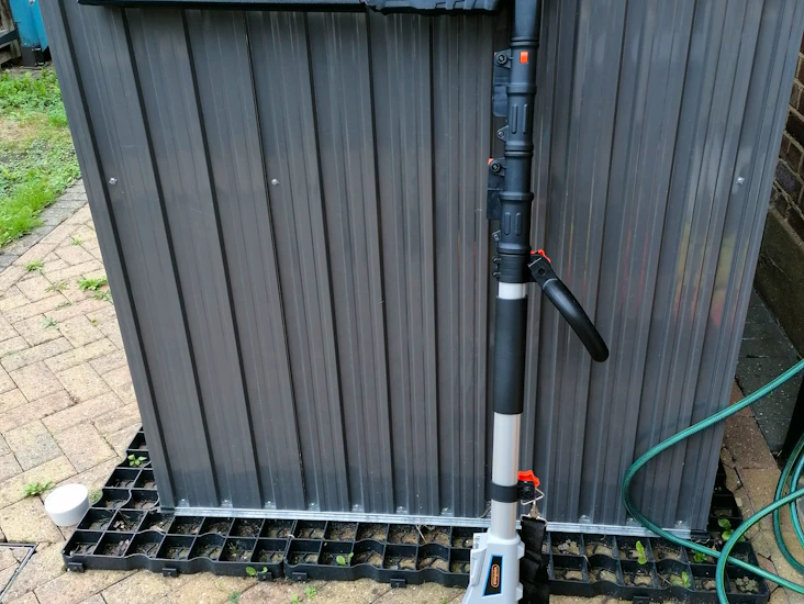 Cordless battery powered long-reach hedge trimmer