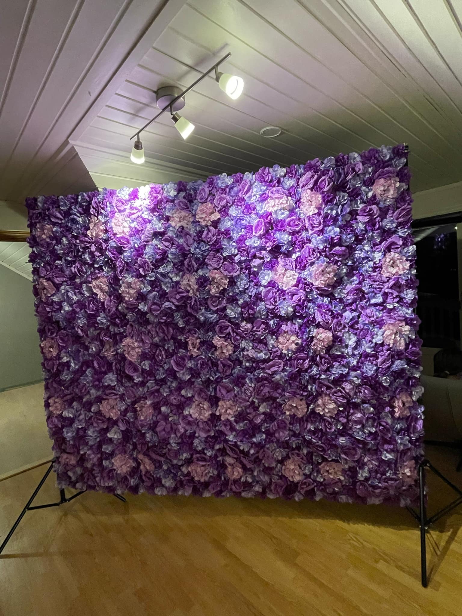 Blomstervegg med stativ og lys