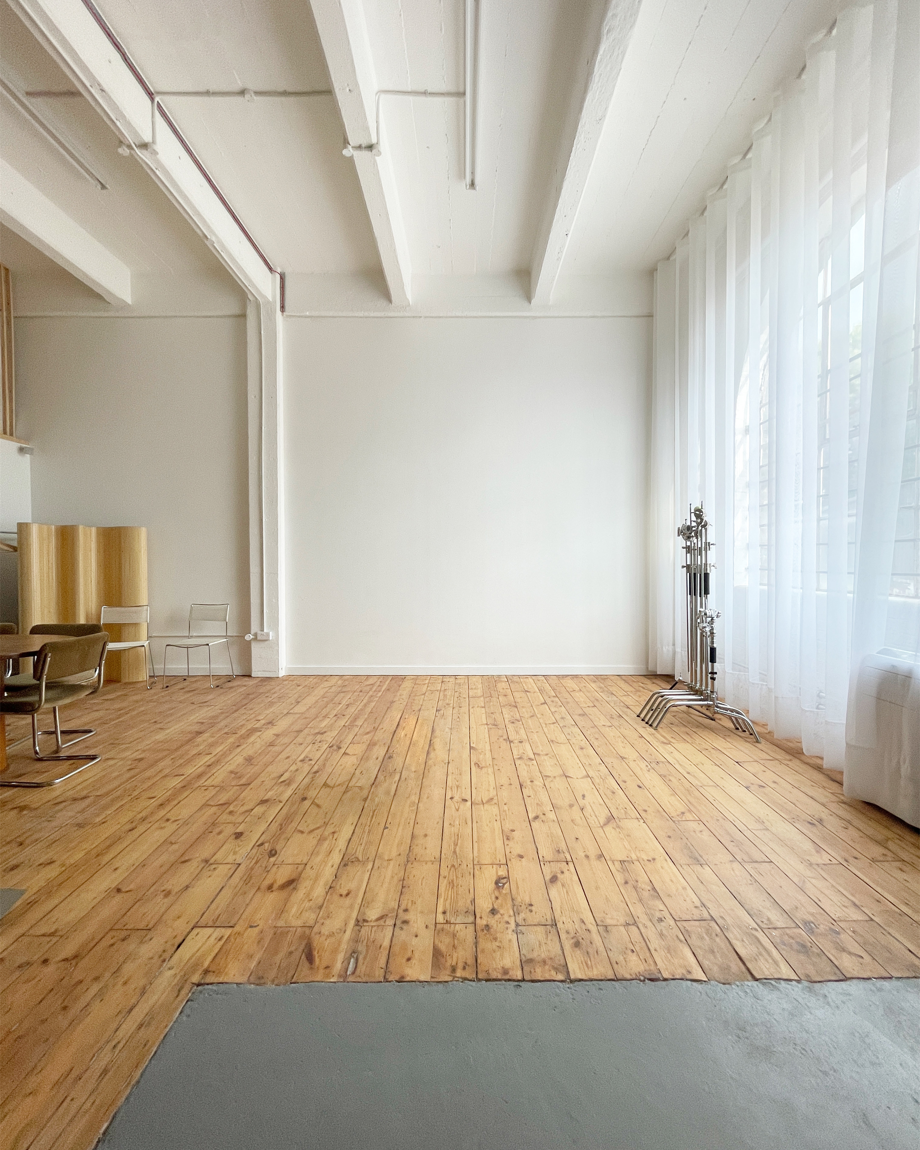 Light daylight studio with wooden floor and high ceiling